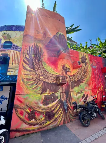 Mural of eagle on wall in Comuna 13 in Medellin with sun peaking over the top of the wall