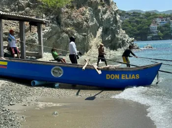 Fishing boat named Don Elias and fishermen pulling in a net