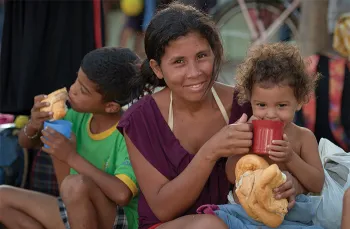 woman holding and feeding children