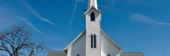 Small white rural church blue sky