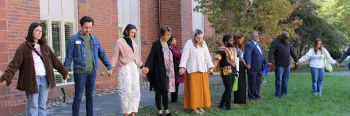 young adults holding hands and praying