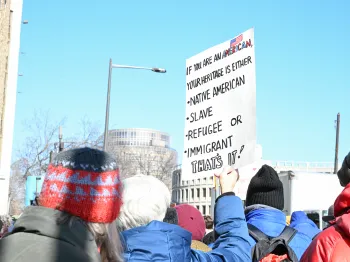 Vigil participant holds a sign in support of immigrants. 