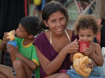 woman holding and feeding children