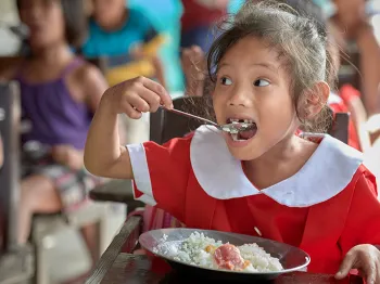 child eating rice