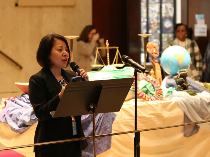 Sue Rheem holding microphone speaking to group of women