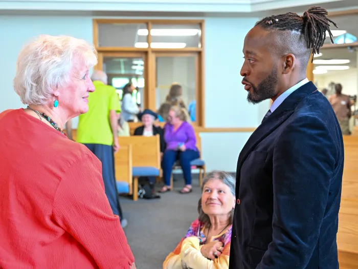 Rev. Ross Allam speaks to two women
