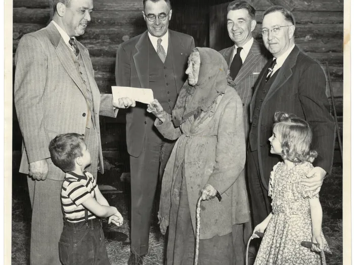 1949 image: men hand elderly woman a check