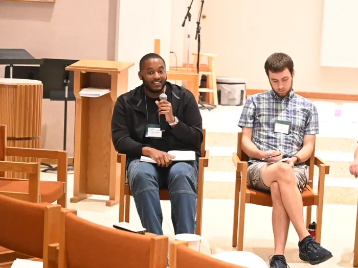Three men sitting in chairs while serving on panel