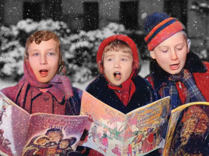Three children sing Christmas carols.