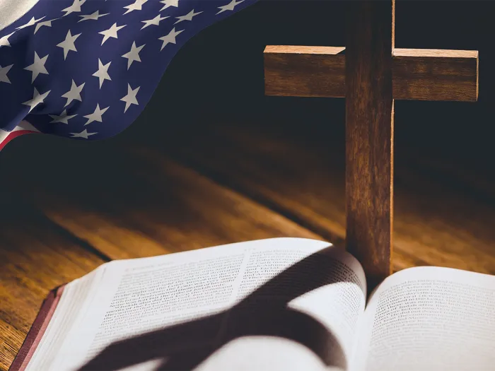 Image of bible and cross with an american flag to the side. 