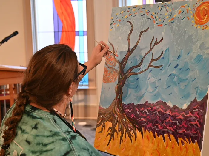 Lauren Christian paints Van Gogh-inspired leaves in worship at the 2026 Jesus and Justice Young Adult Advocacy Conference. 