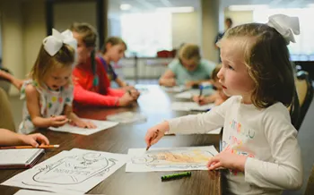 Kids sitting at a table doing crafts.