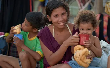 woman holding and feeding children